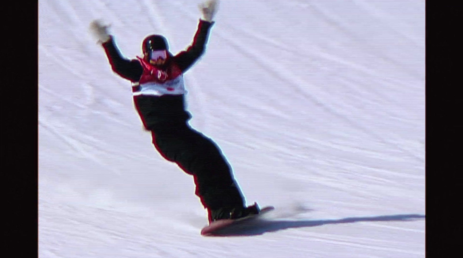 a man riding a snowboard down a snow covered slope