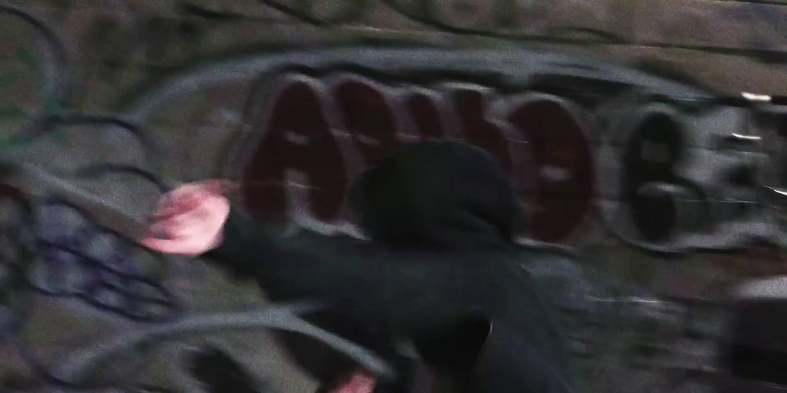 a blurry image of a person in a black hoodie