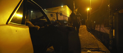 a man standing next to a car at night