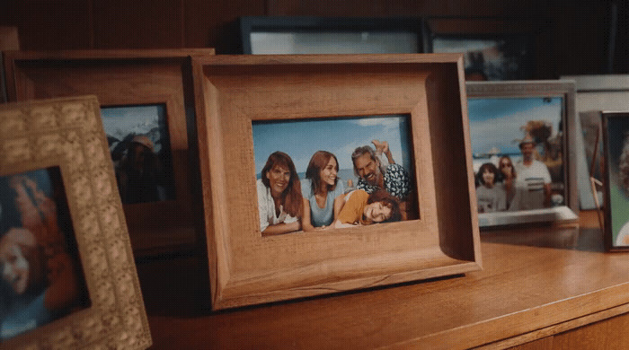 a group of framed pictures sitting on top of a wooden table