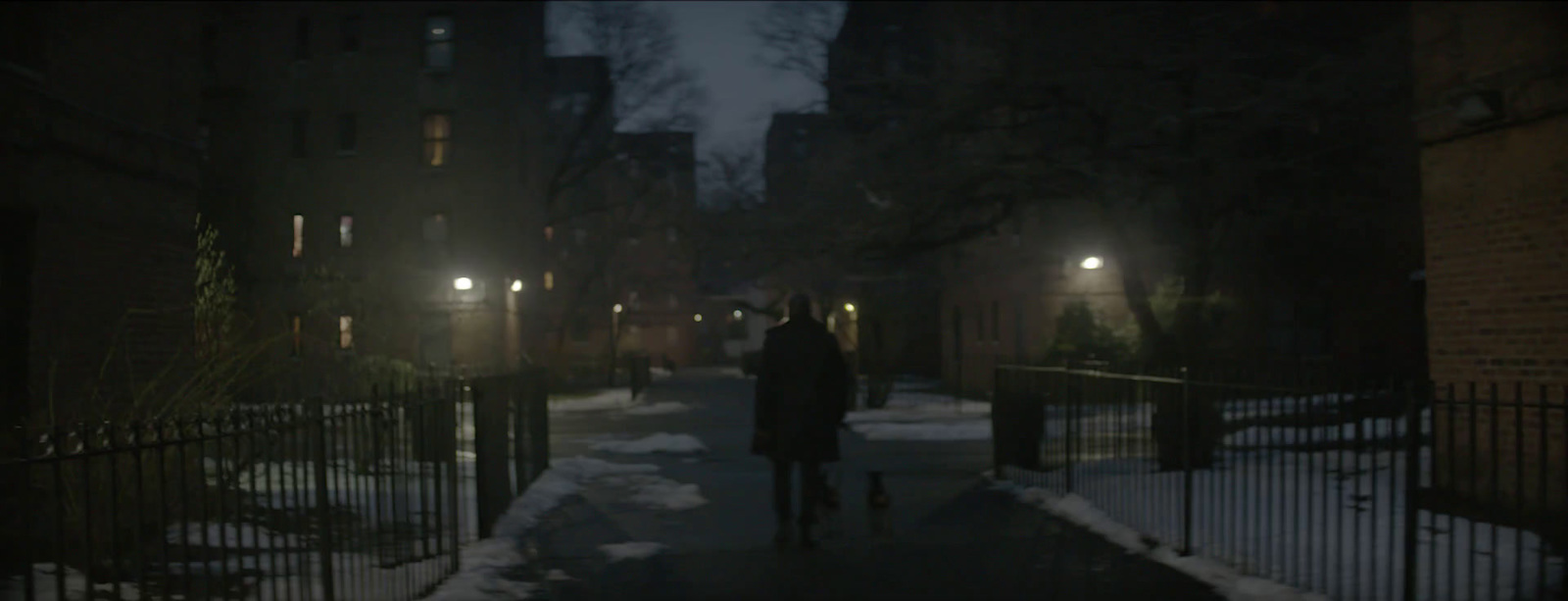 a person walking down a snowy street at night