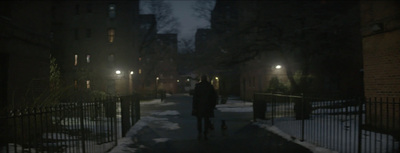 a person walking down a snowy street at night