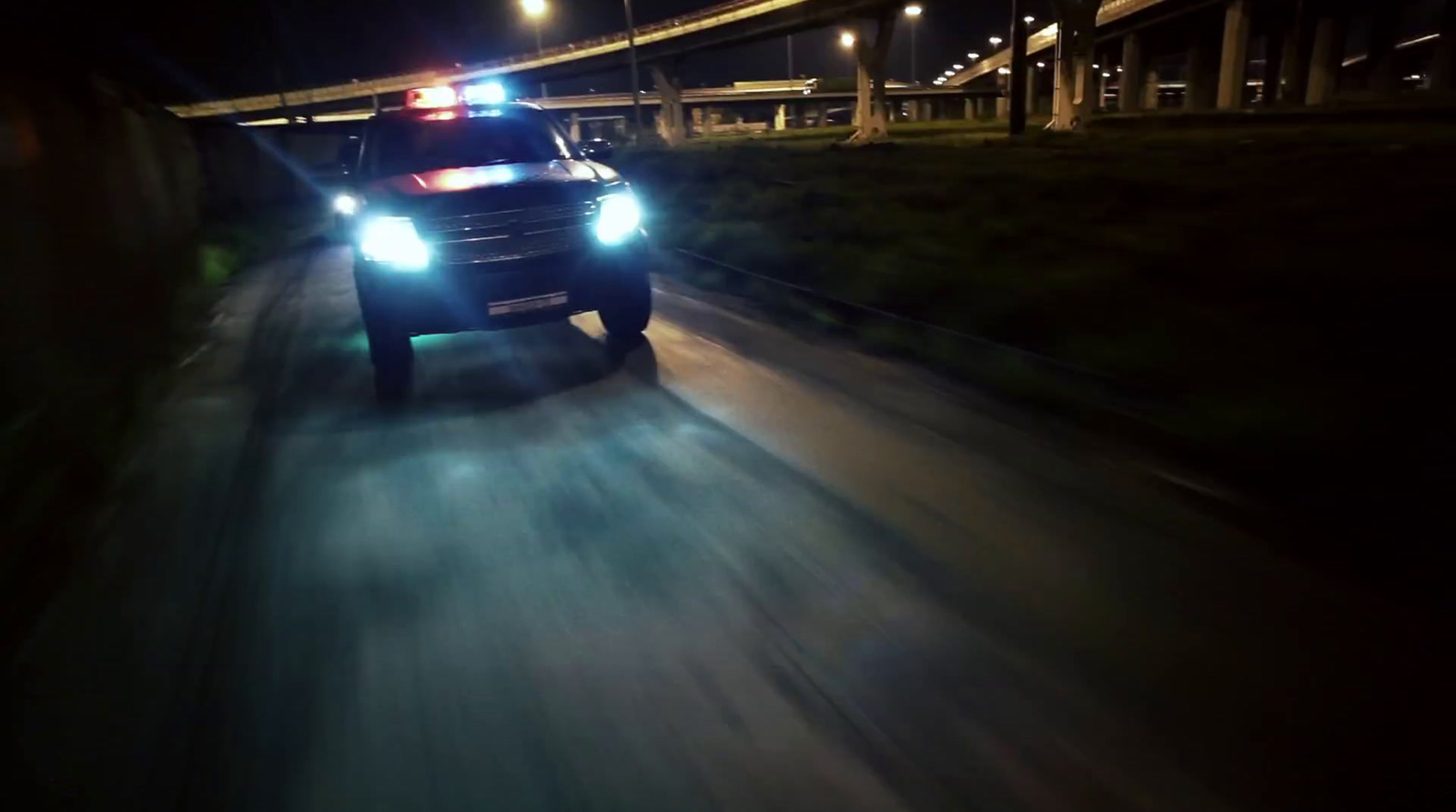 a police car driving down a street at night