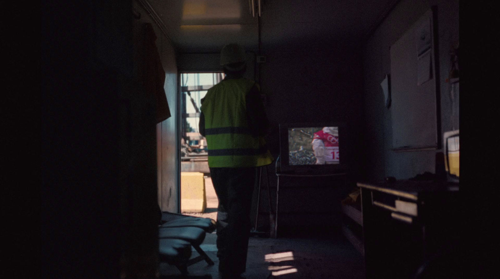 a man standing in a dark room with a television