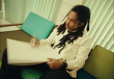 a man with dreadlocks sitting at a table