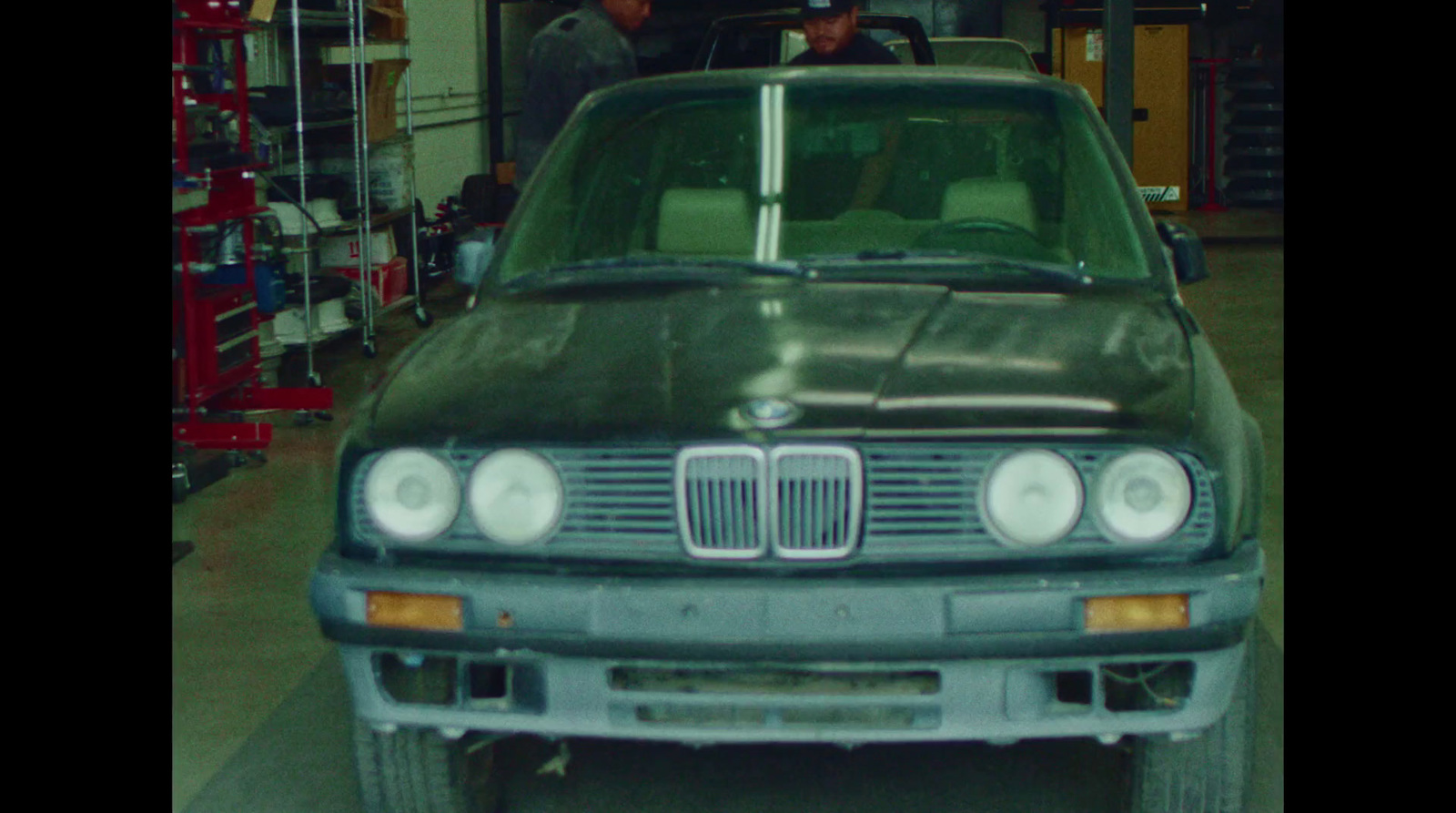 a green car is parked in a garage