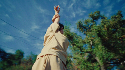 a person in a robe reaching up into the sky