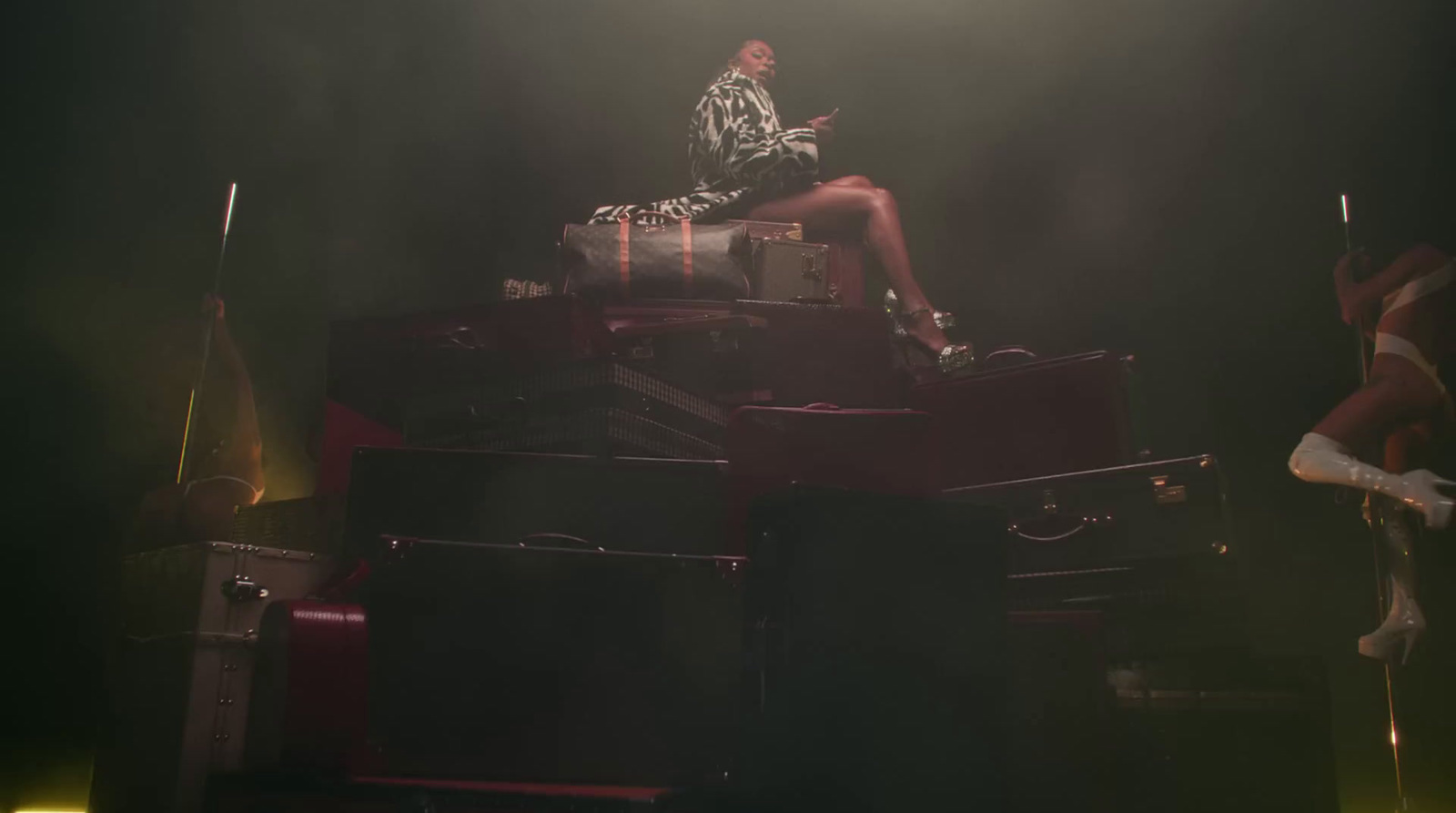 a woman sitting on top of a pile of luggage