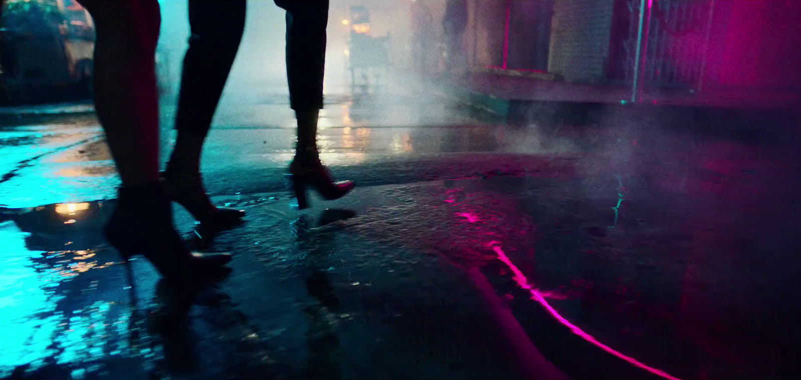 a couple of people standing on a wet street