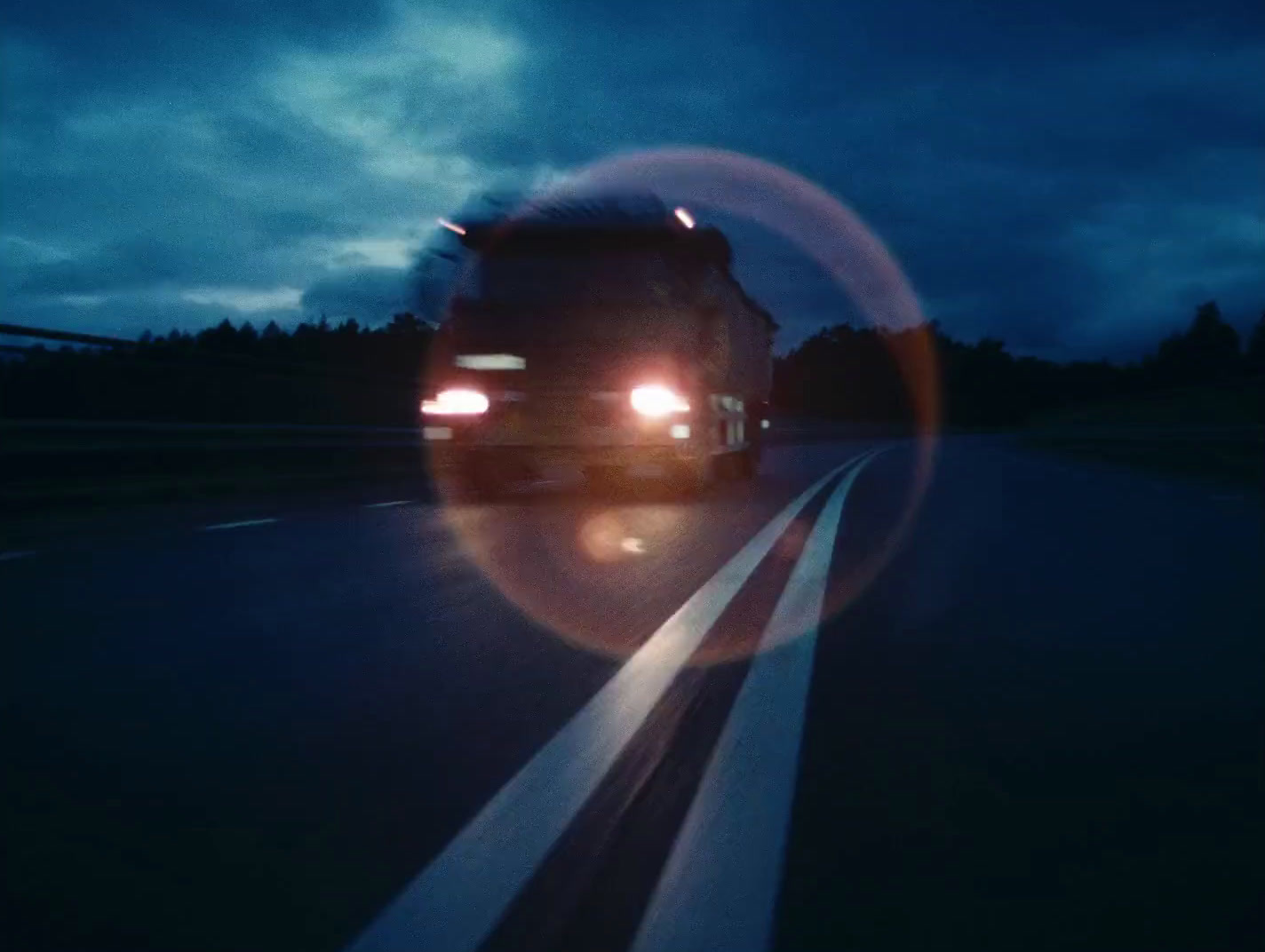 a truck driving down a road at night