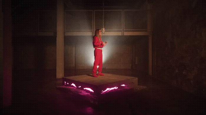 a woman standing on top of a box in a dark room