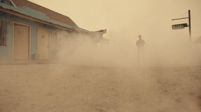 a man standing in the middle of a dust storm