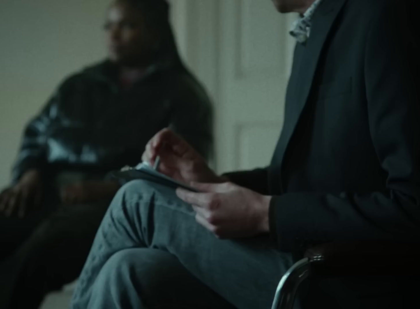 a man sitting in a chair holding a tablet