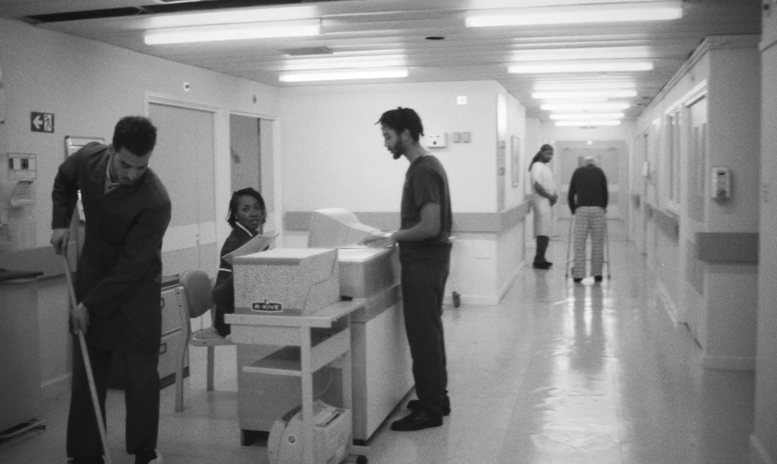 a black and white photo of people in a hallway