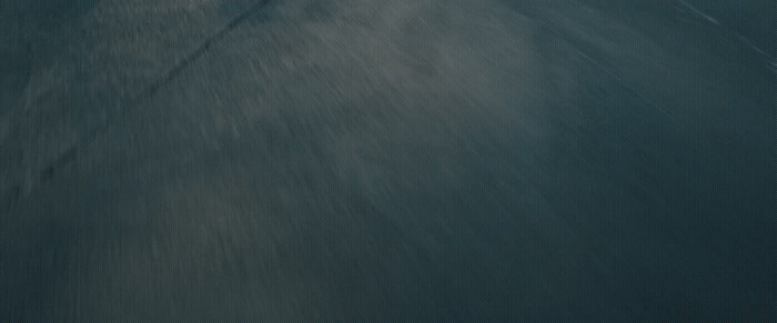 a man riding a snowboard down a snow covered slope