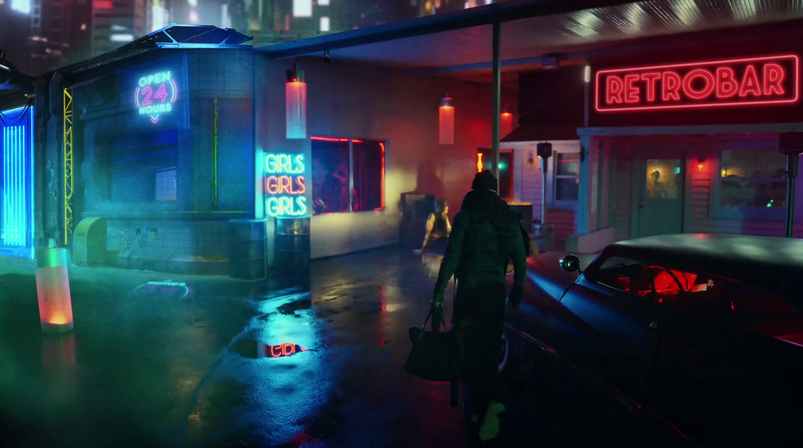 a man walking down a street next to a neon lit building