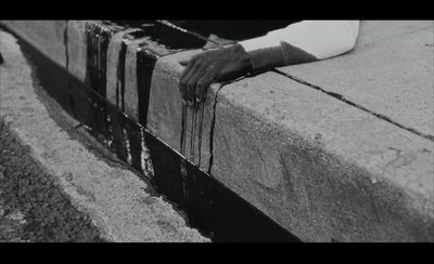 a person sitting on a bench with their hand on the edge of the bench