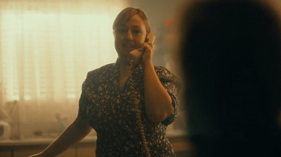 a woman standing in a room talking on a cell phone