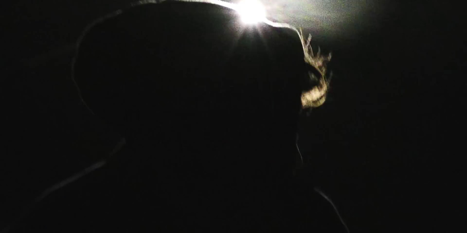 a person standing in the dark with a light shining on their face