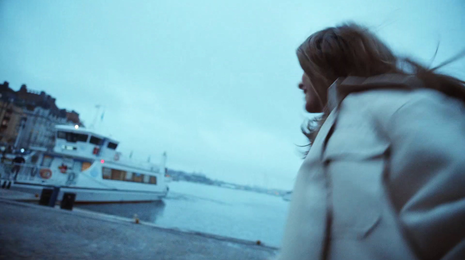 a woman in a white coat is looking at a boat