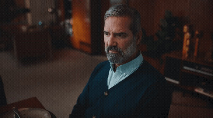 a man with a beard and a blue sweater