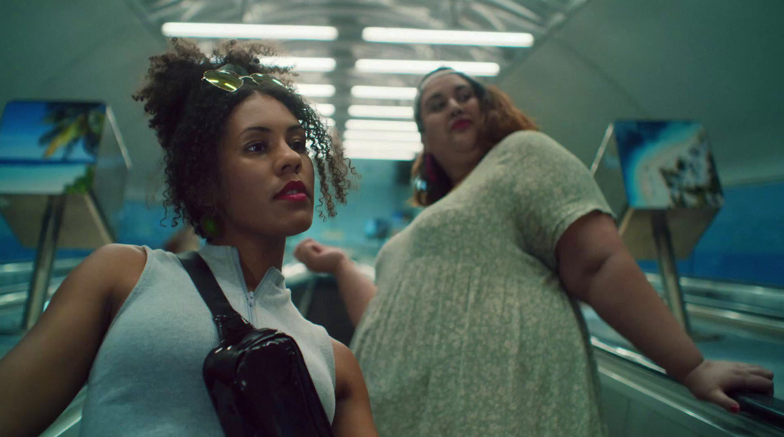 a couple of women standing next to each other on an escalator