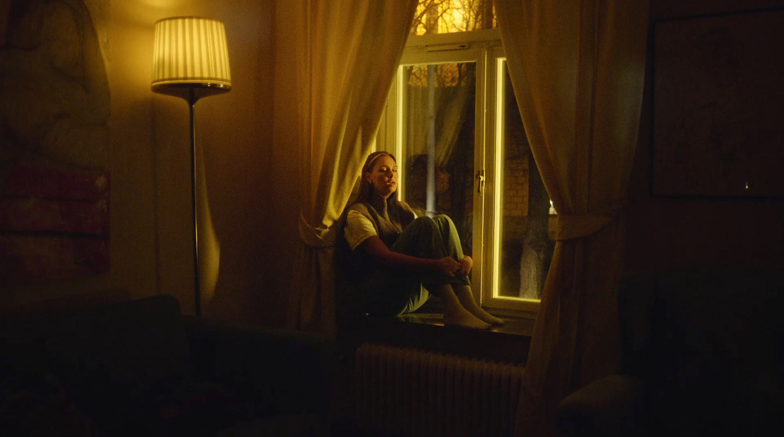 a man sitting in a chair looking out of a window