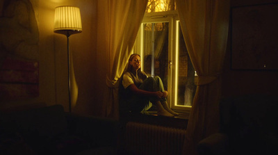 a man sitting in a chair looking out of a window