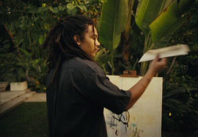 a man with dreadlocks is holding a piece of paper