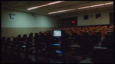 an empty auditorium with rows of chairs and a flat screen tv