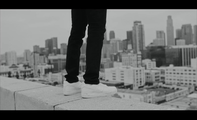 a person standing on a ledge in front of a city