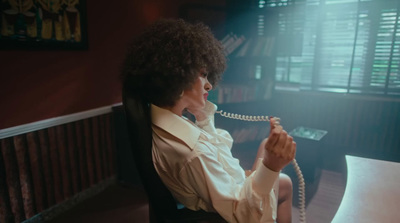 a woman sitting at a desk talking on a phone