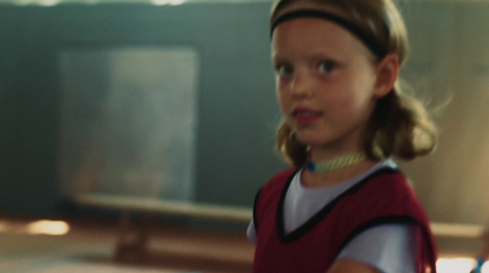 a young girl holding a tennis racquet on a tennis court