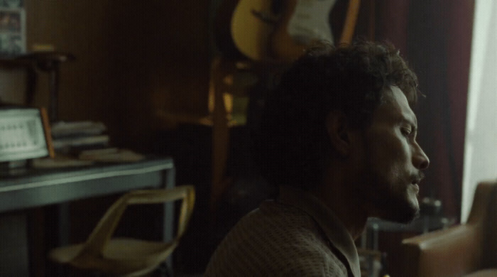 a man sitting in a living room next to a desk