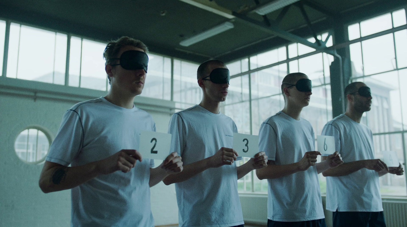 a group of men standing next to each other wearing blindfolds