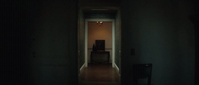 a dark hallway with a chair and a table