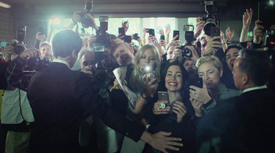 a group of people taking pictures with their cell phones