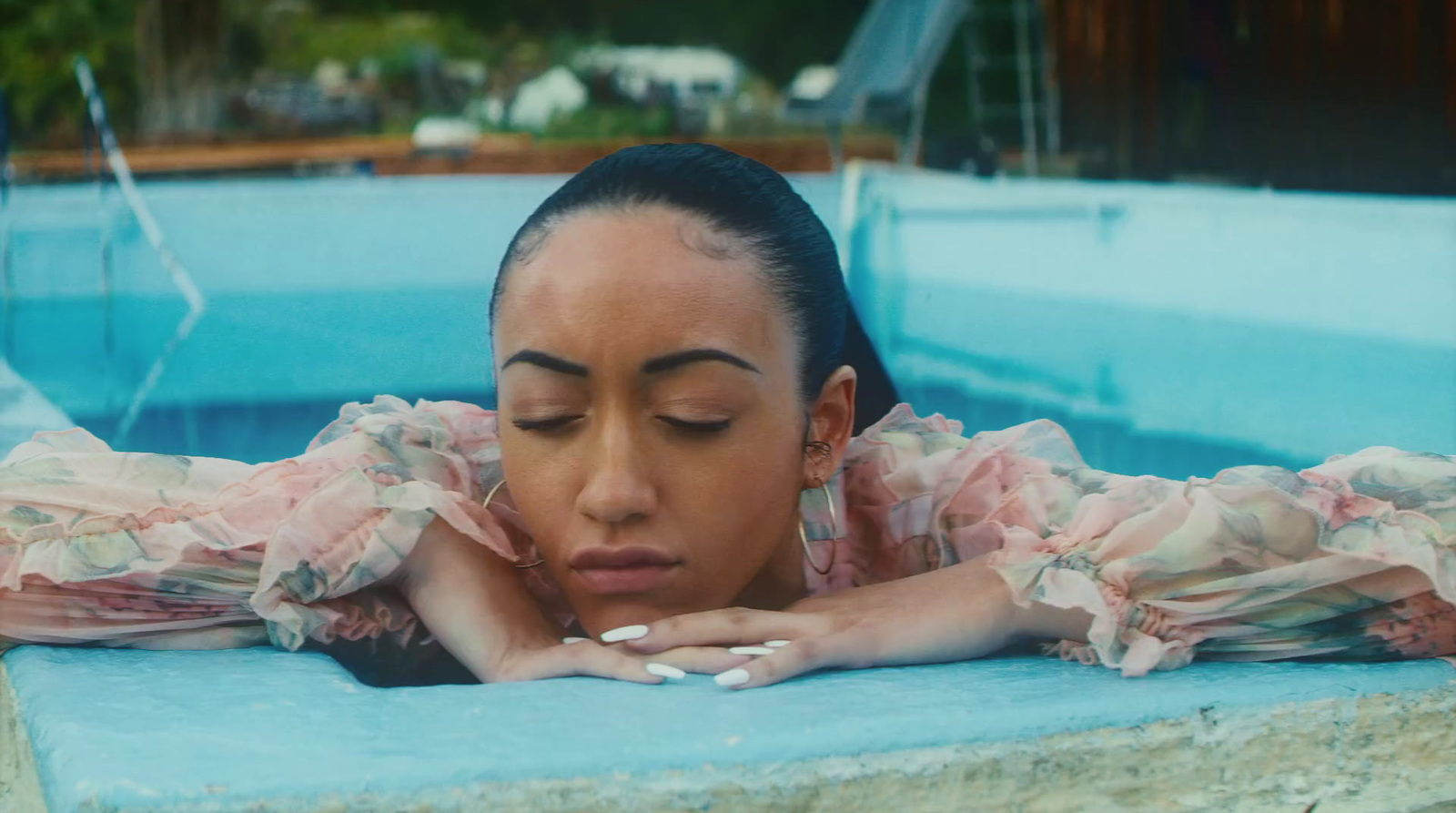 a woman in a pool with her hands on her face