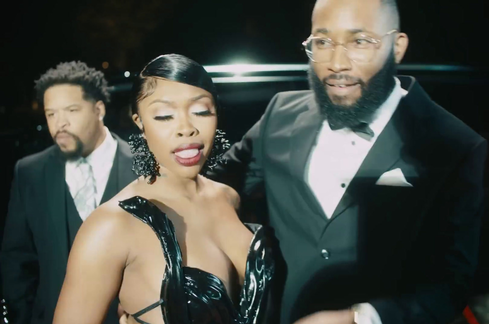 a woman in a black dress standing next to a man in a tuxedo