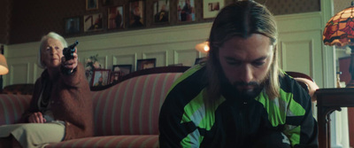 a man with long hair sitting on a couch