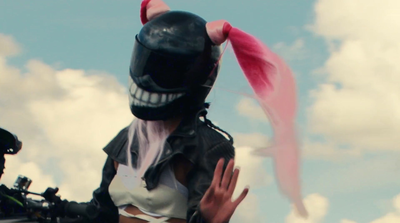 a person wearing a helmet and a mask with pink hair