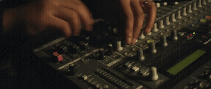 a person using a mixing console in a recording studio