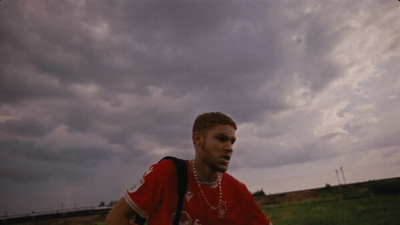 a man in a red shirt standing in a field