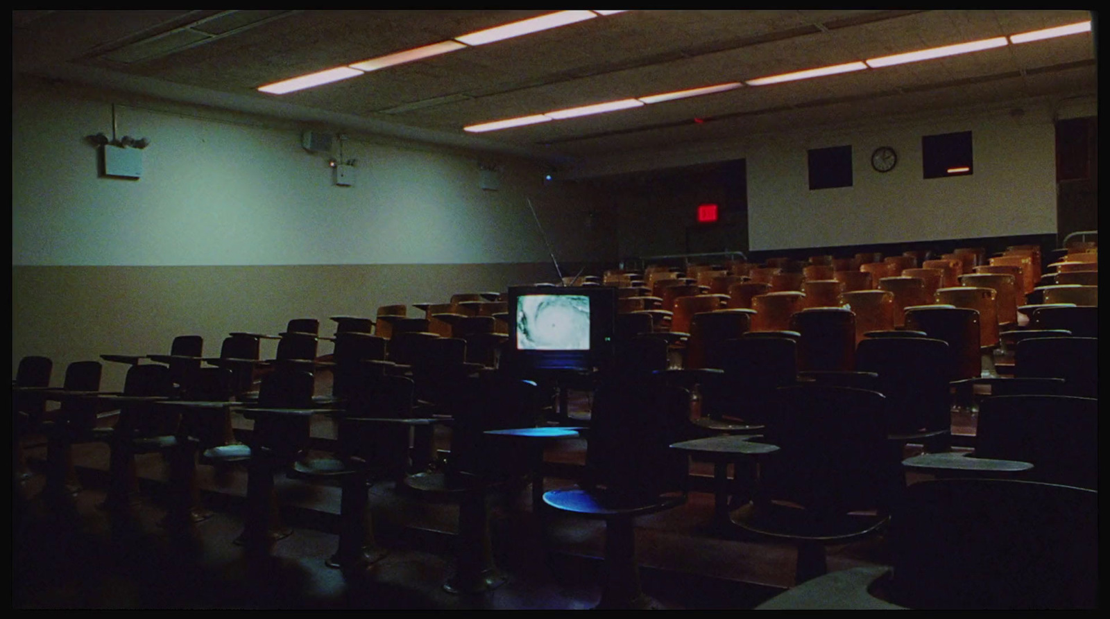 an empty auditorium with rows of chairs and a flat screen tv