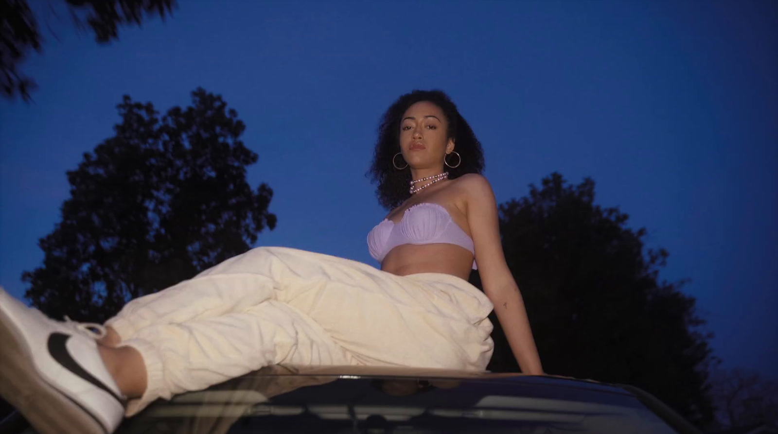 a woman sitting on the hood of a car