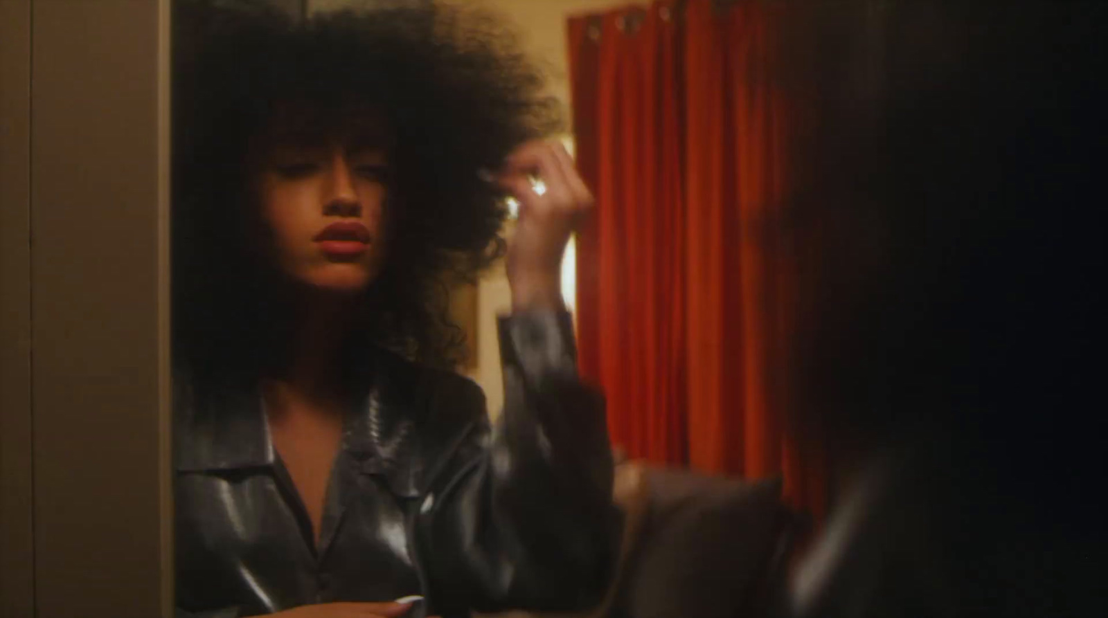 a woman brushing her hair in front of a mirror