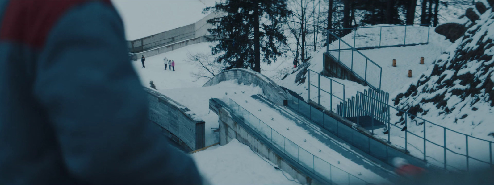 a man standing in the snow next to a ramp