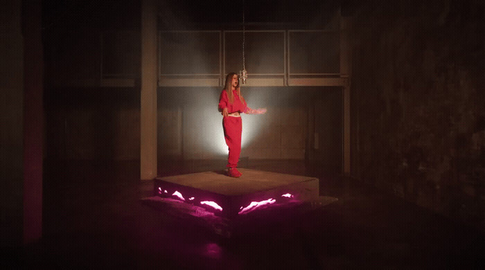 a woman standing on a platform in a dark room