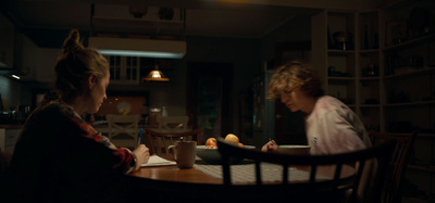 two women sitting at a table in a dark room