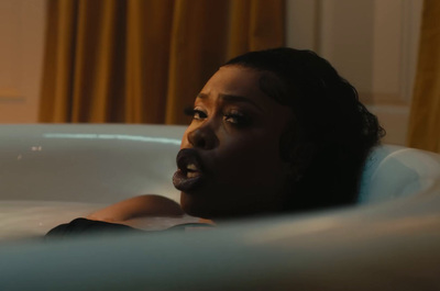 a woman laying in a bathtub with a surprised look on her face